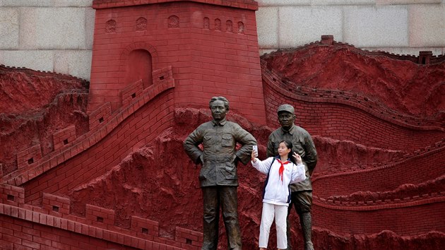 Dvka se fot u soch dikttora Mao Ce-Tunga a vojevdce u Teho. na slav 50 let od vyhlen Kulturn revoluce. (15. kvtna 2016)