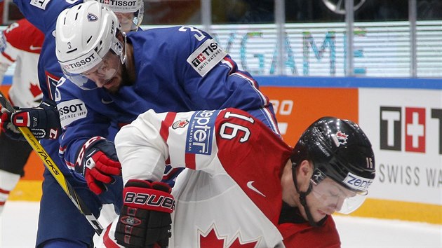 Kanadsk hokejista Max Domi si kryje puk ped Francouzem Jonathanem Janilem.