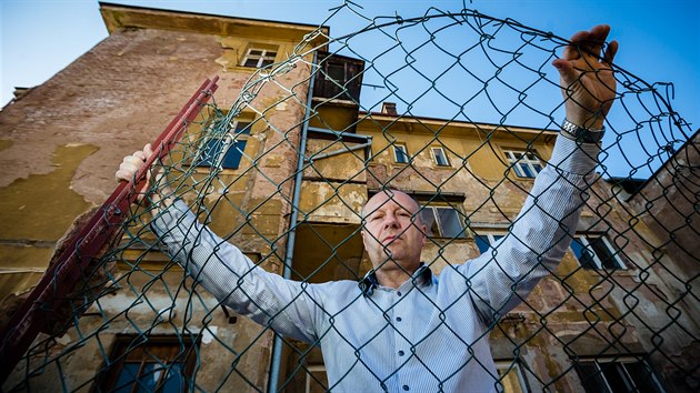 Pavel Kalina za plotem, kter� je podle n�j �ernou stavbou.