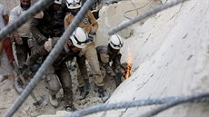 Písluníci Syrské civilní obrany prohledávají trosky rozbombardovaného domu v...