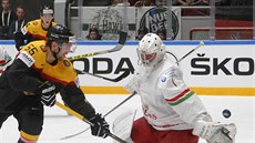 Nmecký hokejista Felix Schütz pekonává bloruského brankáe Vitalije Kovala.