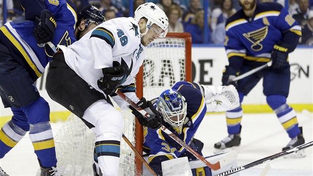 Tom Hertl ze San Jose si najd ped branku, glman St. Louis Jake Allen se mu sna vypchnout puk.