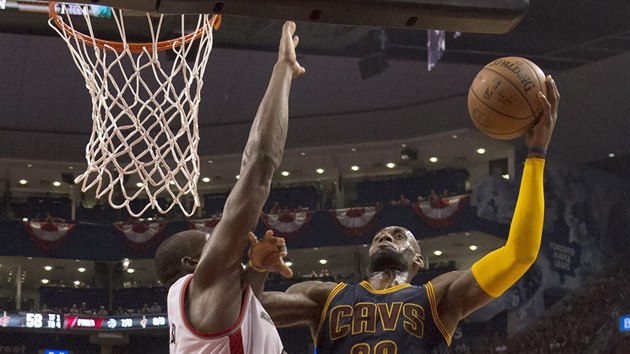 LeBron James (vpravo) z Clevelandu zakonuje pes  Bismacka Biyomba z Toronta.