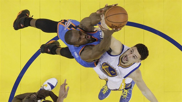 Klay Thompson z Golden State (vpravo) v souboji o odraen m se Sergem Ibakou z tmu Oklahoma City.