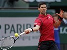 Novak Djokovi se napahuje k úderu v utkání s Tomáem Berdychem.