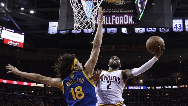 Kyrie Irving z Clevelandu se peosazuje pod koem, brn ho Anderson Varejao z Golden State.