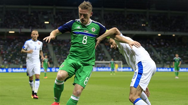 Steven Davis ze Severnho Irska (vlevo) a Duan vento ze Slovenska v boji o m