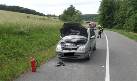 Majiteli hoícího vozu pomohl jiný idi, který s sebou vezl hasicí pístroj.