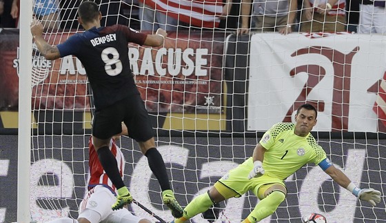 Americký fotbalista Clint Dempsey práv pekonává paraguayského gólmana Justa...