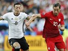 Nmecký záloník Mesut Özil stíhá Poláka Grzegorze Krychowiaka.