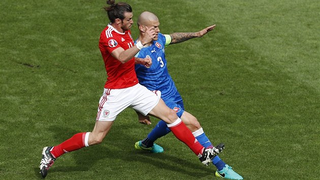 Hvězda Walesu Gareth Bale se přetalčuje o balon s kapitánem Slováků Martinem Škrtelem.