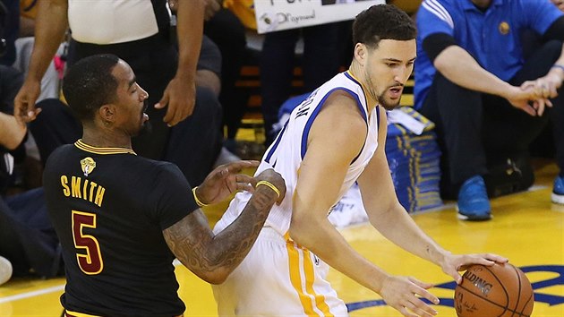 Klay Thompson (vpravo) z Golden State se tla pod ko Clevelandu pes J. R. Smithe.