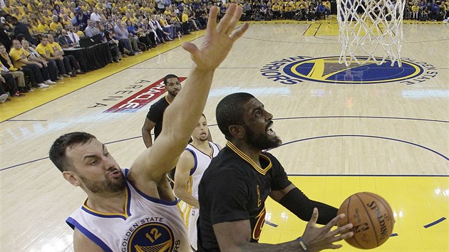 Kyrie Irving z Clevelandu pilt ke koi Golden State, zezadu se o blok sna Andrew Bogut.