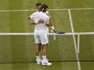DÍKY ZA HRU. Roger Federer (zády) se objímá u sít po výhe nad britským...