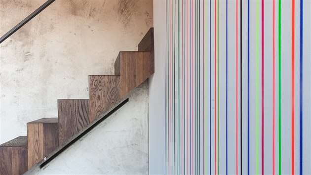 Detail vloženého schodiště - dřevo a betonová stěrka, ale také originální obraz v barvě schodiště, do kterého je zasazena pohovka na míru.