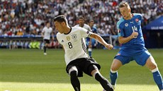 Slovenský záložník Milan Škriniar sleduje německého špílmachra Mesuta Özila.