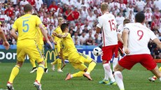 Polský záloník Jakub Blaszczykowski stílí gól mezi ukrajinskými obránci na...