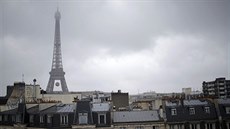 S MÍČEM. Fotografie zachycuje střechy pařížských domů, za nimi se tyčí...