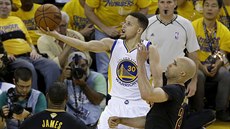 Stephen Curry (v bílém) z Golden State jde s míem do koe Clevelandu, brání ho...