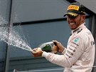 NA PÓDIU. Lewis Hamilton slaví vítzství ve Velké cen Rakouska.