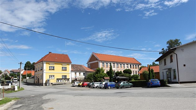 Bývalá škola ve Vojkově je na jedné straně návsi, na té protilehlé je kostel s farou.