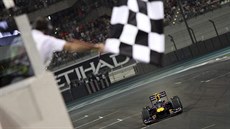 Cíl závodu formule 1 s achovnicovým praporem. Vítzí Vettel z Red Bullu.