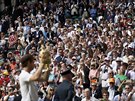 Andy Murray ukazuje fanoukm trofej pro vítze Wimbledonu.