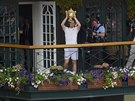 POZDRAV Z BALKÓNU. Andy Murray ukazuje fanoukm trofej pro vítze Wimbledonu.