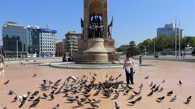 ena krmí holuby na námstí Taksin v Istanbulu. V noci se zde shromádili...