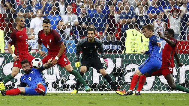TO JE MELA. Francouzský útočník Olivier Giroud na zemi bojuje o míč proti přesile portugalských obránců.