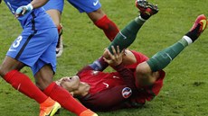 JAUUUU. Cristiano Ronaldo se drí za koleno po bolestivém souboji s Payetem....