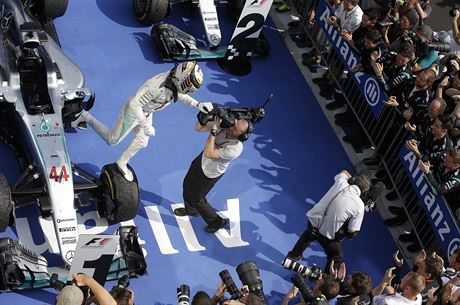 RADOSTNÝ VÝSKOK. Lewis Hamilton spchá z vozu slavit vítzství na Velké cen...