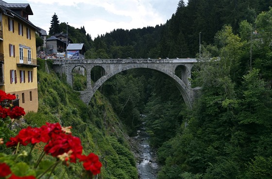 Skupina cyklist� p�ej�d� most ve Flumetu b�hem dvac�t� etapy z�vodu Tour de...