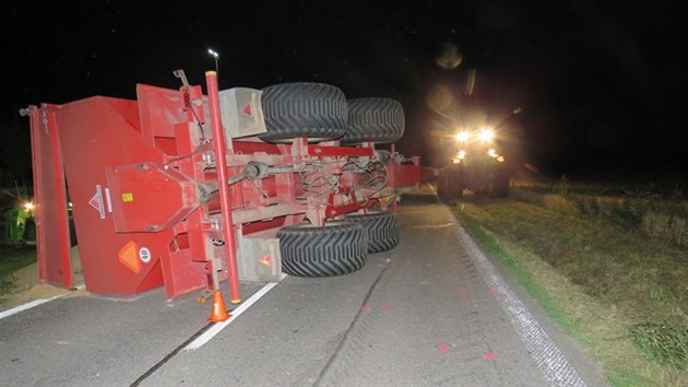Přívěs traktoru se při nehodě převrátil na bok.