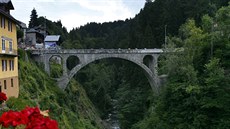 Skupina cyklist pejídí most ve Flumetu bhem dvacáté etapy závodu Tour de...