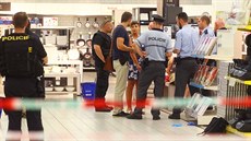 Policisté odvádjí enu, která zabíjela v obchodním centru v Praze na Smíchov (21.7.2016)