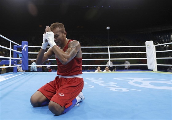 Thajský boxer Amnat Ruenroeng se modlí po výhe nad Argentincem Ignaciem.