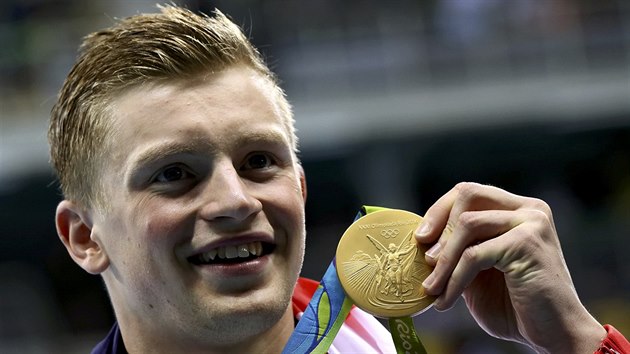 Britsk plavec Adam Peaty hrd ukazuje olympijsk zlato z trati sto metr prsa.