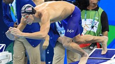 Americký plavec Michael Phelps skáe do bazénu pi tafet na 4x100 metr.