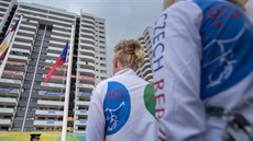 etí sportovci sledují slavnostní vyvení státní vlajky v olympijské vesnici.