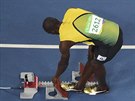 Usain Bolt si pipravuje bloky pro start semifinále na dvoustovce.