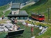Červený vlak Jungfraubahn u vodní nádrže, která v létě osvěžuje turisty. Chodí...