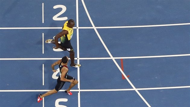 Usain Bolt probíhá cílem semifinálové dvoustovky po boku s Kanaďanem de Grasem.