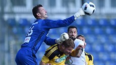 VE VZDUCHU. Karvinský branká� Jan La�t�vka boxuje mí� p�i ligovém utkání v...