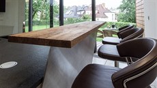 Kuchyňský ostrůvek je vybavený ocelovou stěnou, která drží dřevěnou barovou...