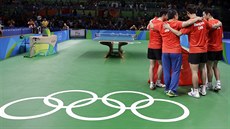 Čínští stolní tenisté se radují z olympijského triumfu v soutěži družstev.