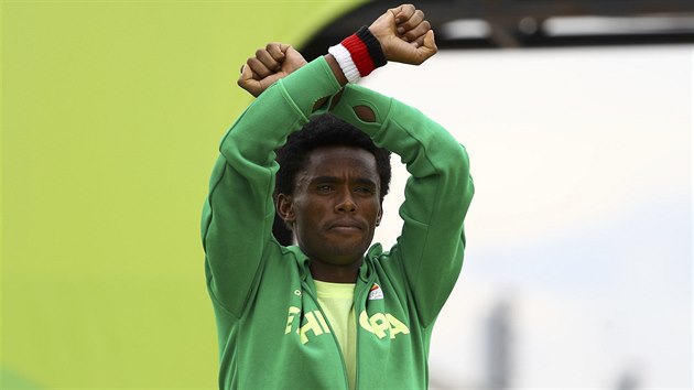 STBRN PROTEST. Vytrvalec Feyisa Lilesa pi vyhlen vtz olympijskho maratonu jet jednou zkil ruce nad hlavou na protest proti pronsledovn Orom v Etiopii.