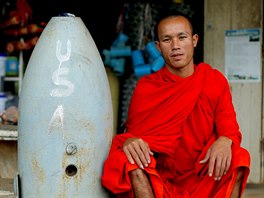 PAMÁTKA NA VIETNAM. Buddhistický mnich pózuje vedle nevybuchlé americké bomby v...