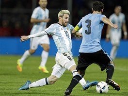 Argentinec Lionel Messi bojuje o m s Diegem Godinem z Uruguaye.