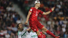 Milan �koda hlavi�kuje, obránce Severního Irska Jonny Evans p�ihlí�í.